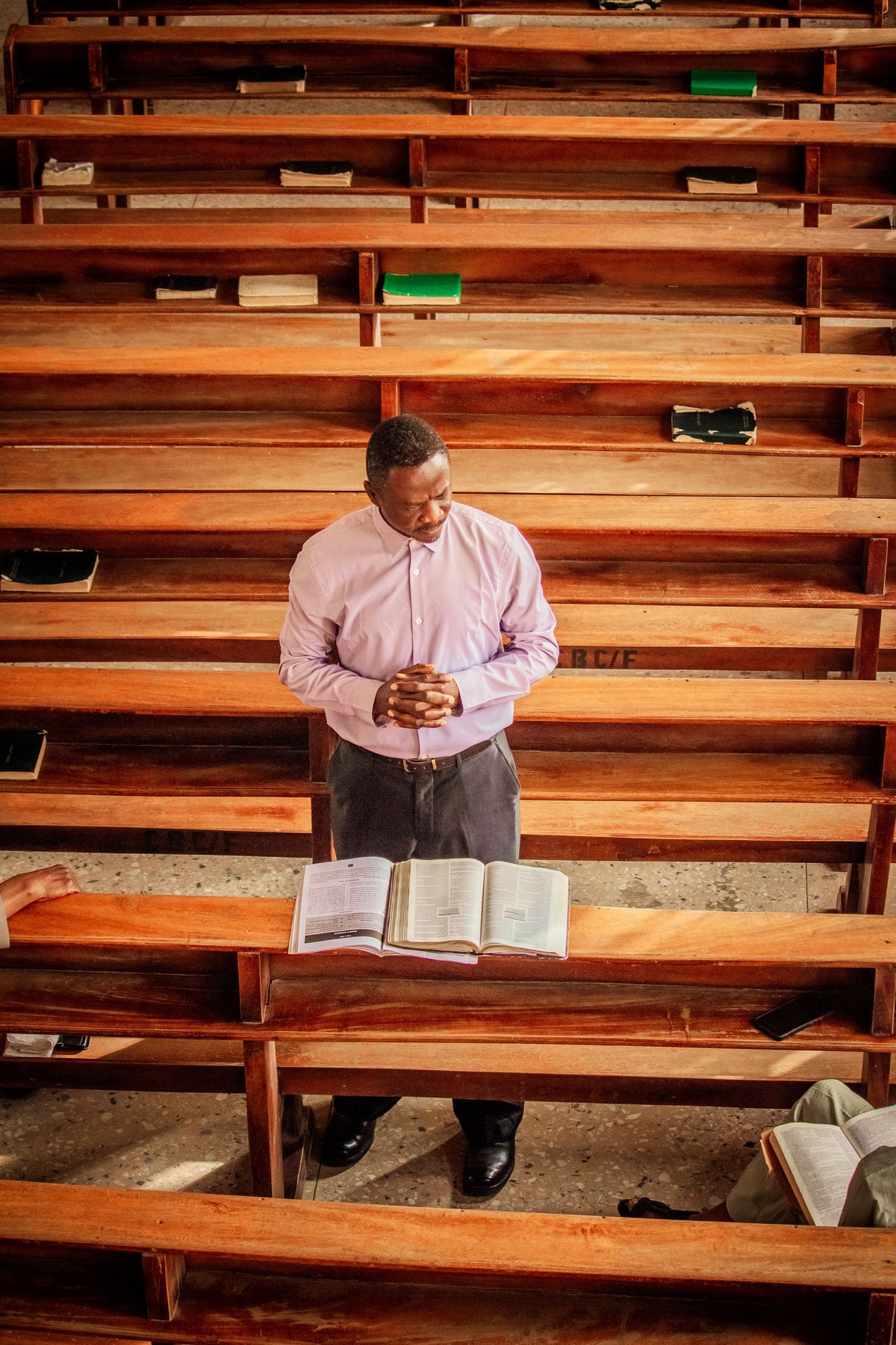Empty church pews, man praying alone