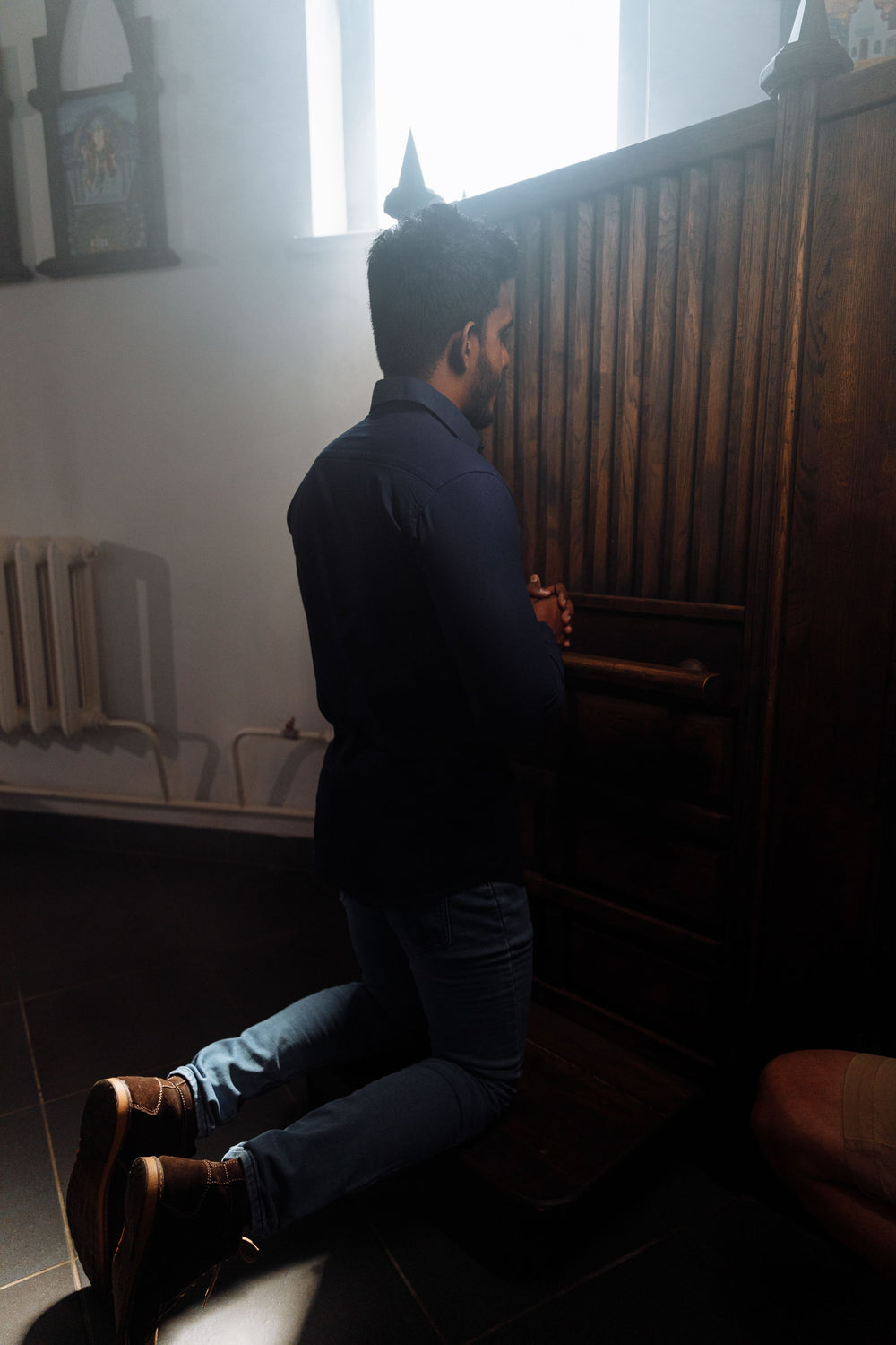 Man kneeling at a confessional